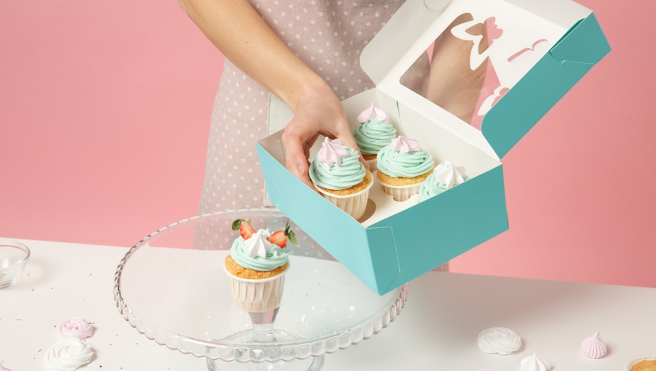 women taking out cup cakes from box